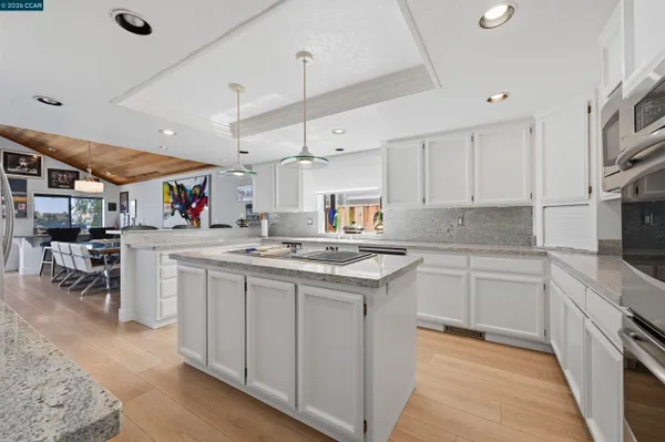 a kitchen with stainless steel appliances granite countertop a stove refrigerator sink and cabinets