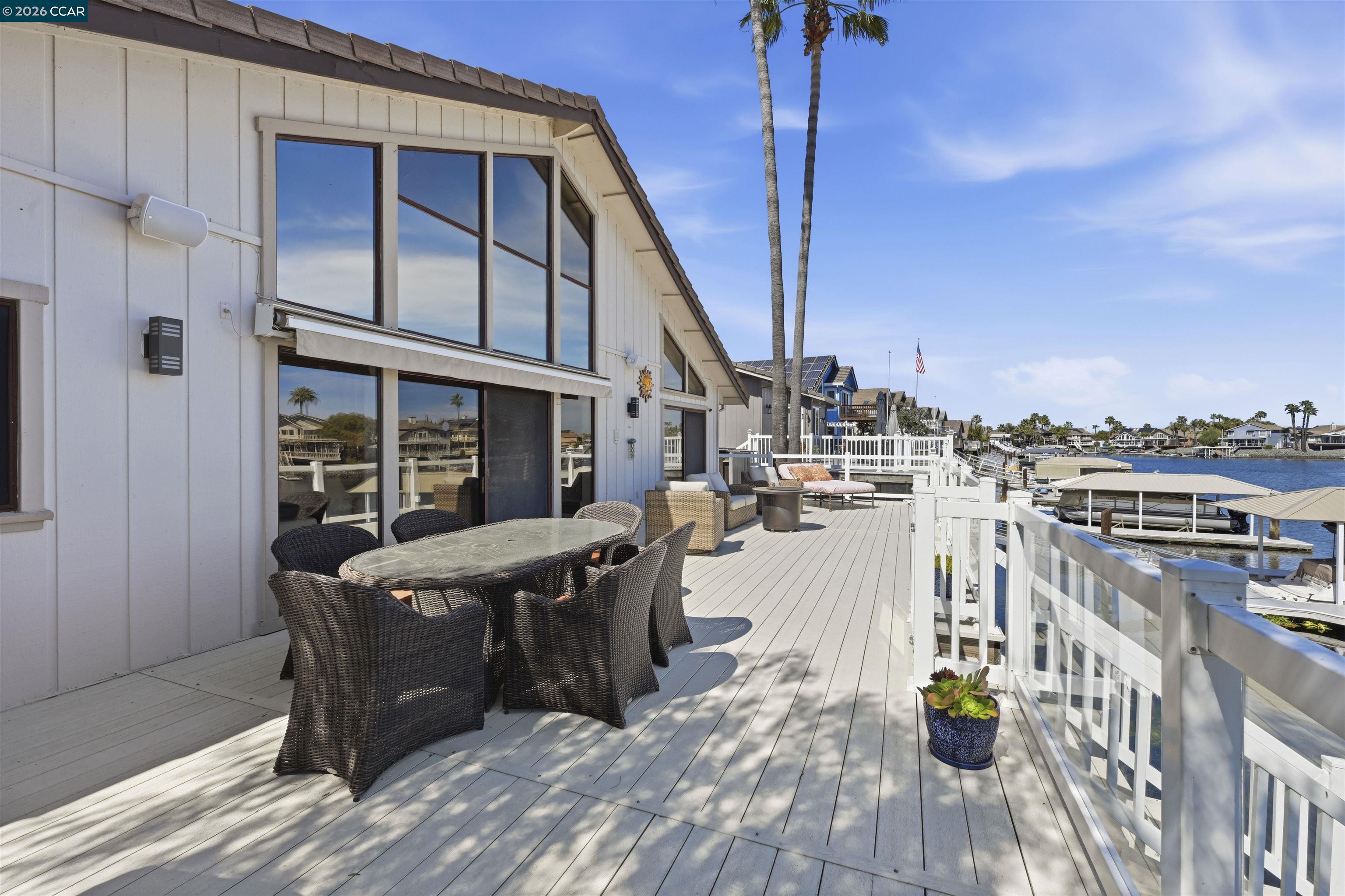 2027 Windward Point Discovery Bay, CA 94505 - Photo 44 of 53 a view of roof deck with table and chairs a barbeque with wooden floor and fence