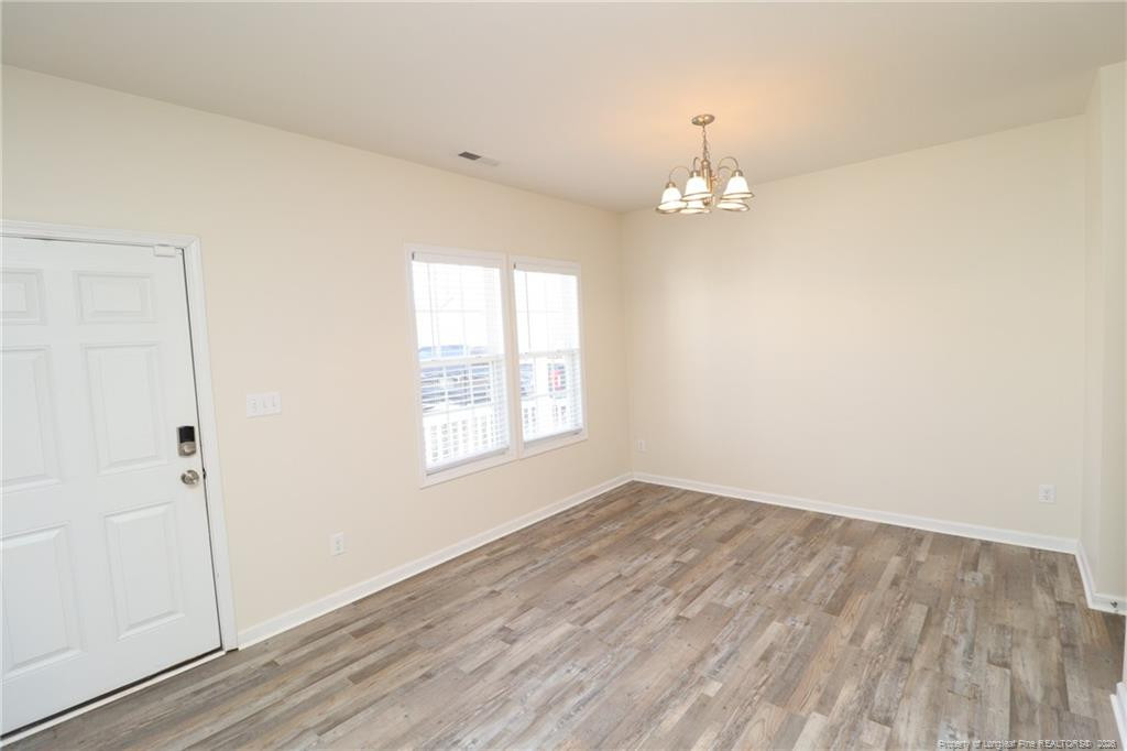2936 Filbert Street Raleigh, NC 27610 - Photo 2 of 27 wooden floor in an empty room with a window