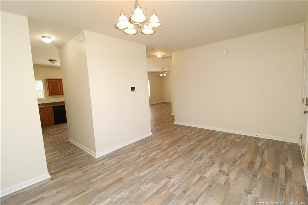 2936 Filbert Street Raleigh, NC 27610 - Photo 4 of 27 wooden floor in an empty room with a kitchen