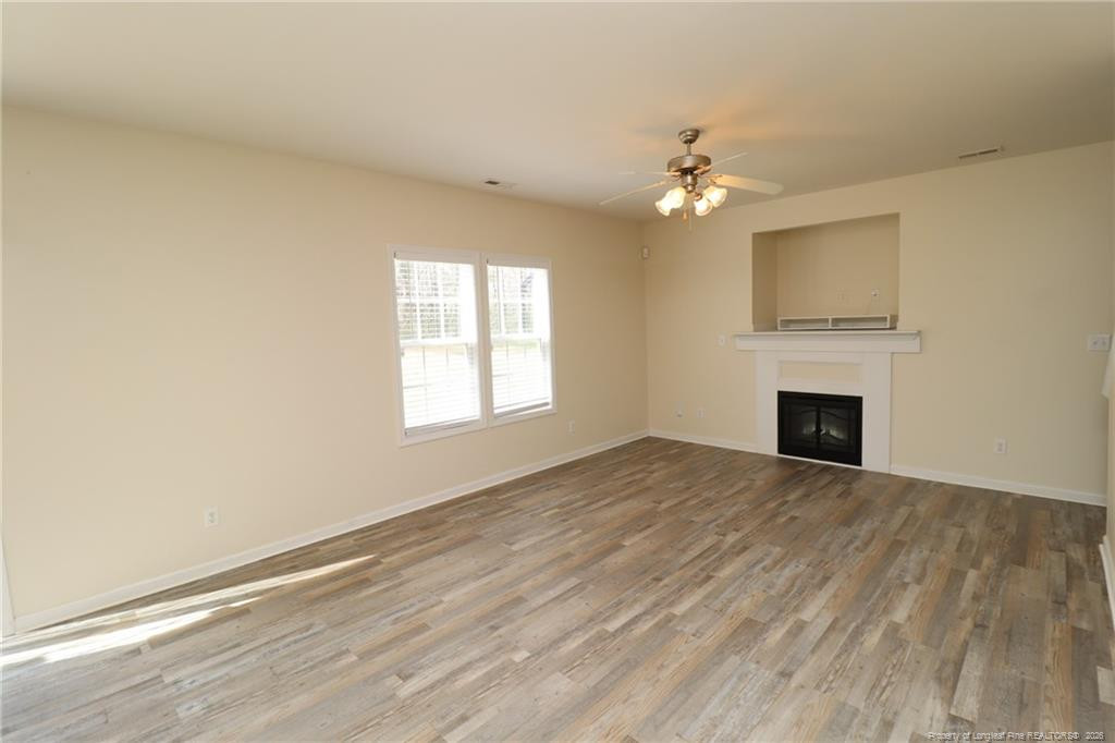 2936 Filbert Street Raleigh, NC 27610 - Photo 5 of 27 an empty room with windows and fireplace