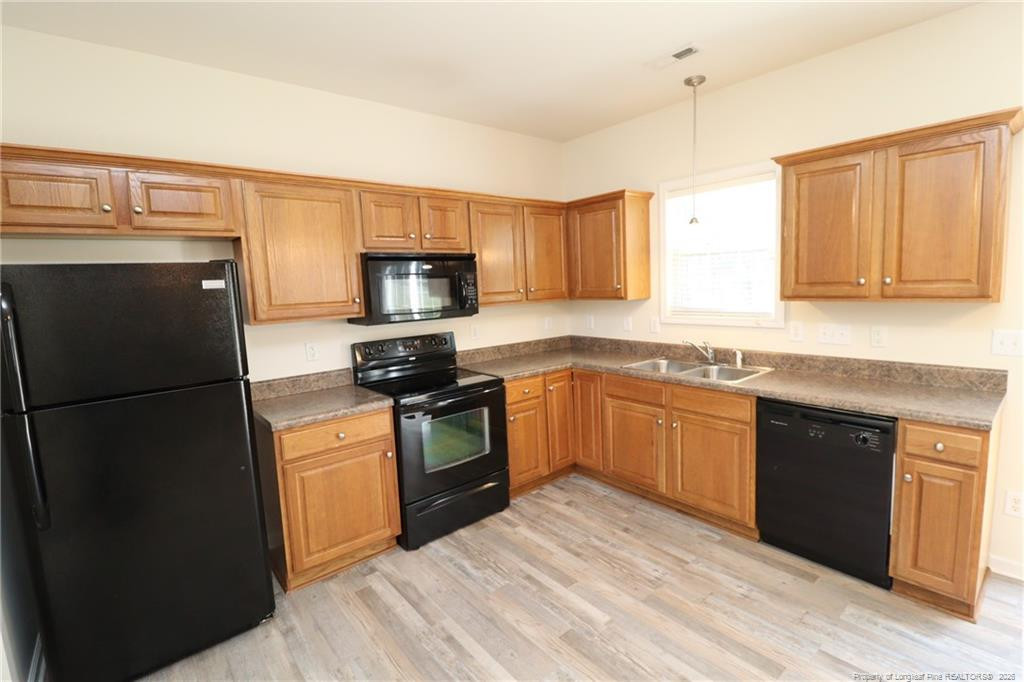 2936 Filbert Street Raleigh, NC 27610 - Photo 9 of 27 a kitchen with a refrigerator sink and microwave
