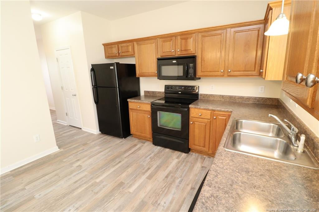 2936 Filbert Street Raleigh, NC 27610 - Photo 10 of 27 a kitchen with stainless steel appliances granite countertop a refrigerator stove and sink