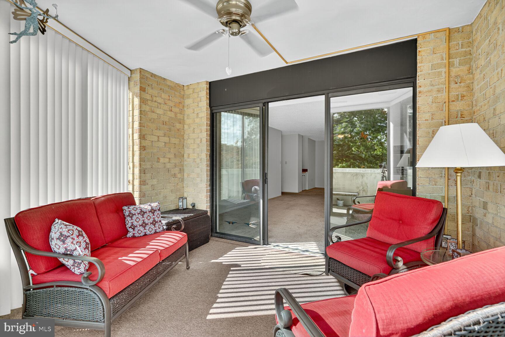 15101 Interlachen Drive, Unit 1123 Silver Spring, MD 20906 - Photo 17 of 29 a living room with furniture a large window and a chandelier