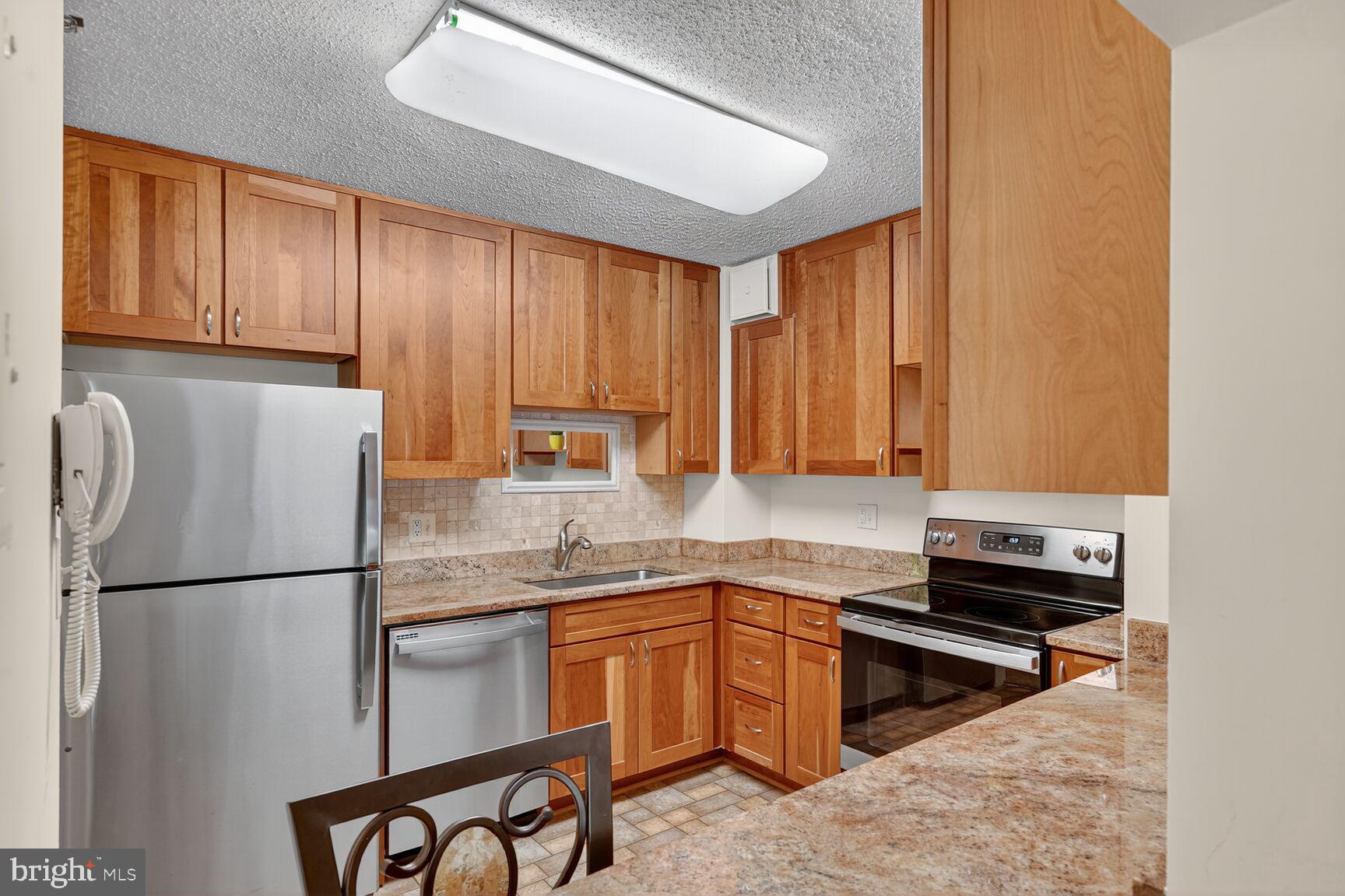 15101 Interlachen Drive, Unit 1123 Silver Spring, MD 20906 - Photo 4 of 29 a kitchen with a refrigerator and a sink