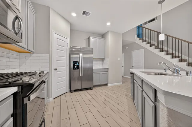 a kitchen with kitchen island a sink stove and refrigerator
