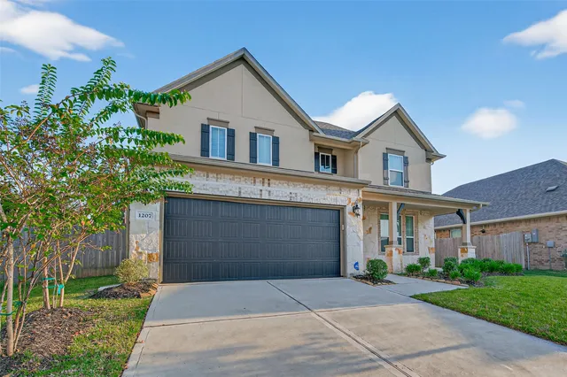 a front view of a house with a garden and trees