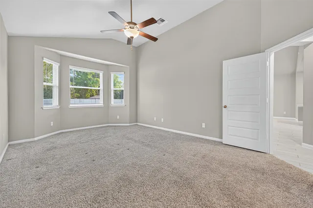 an empty room with windows and fan