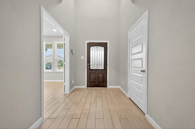 a view of a hallway with wooden floor and a bathroom