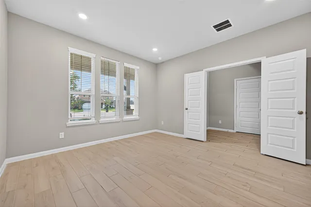wooden floor in an empty room with a window