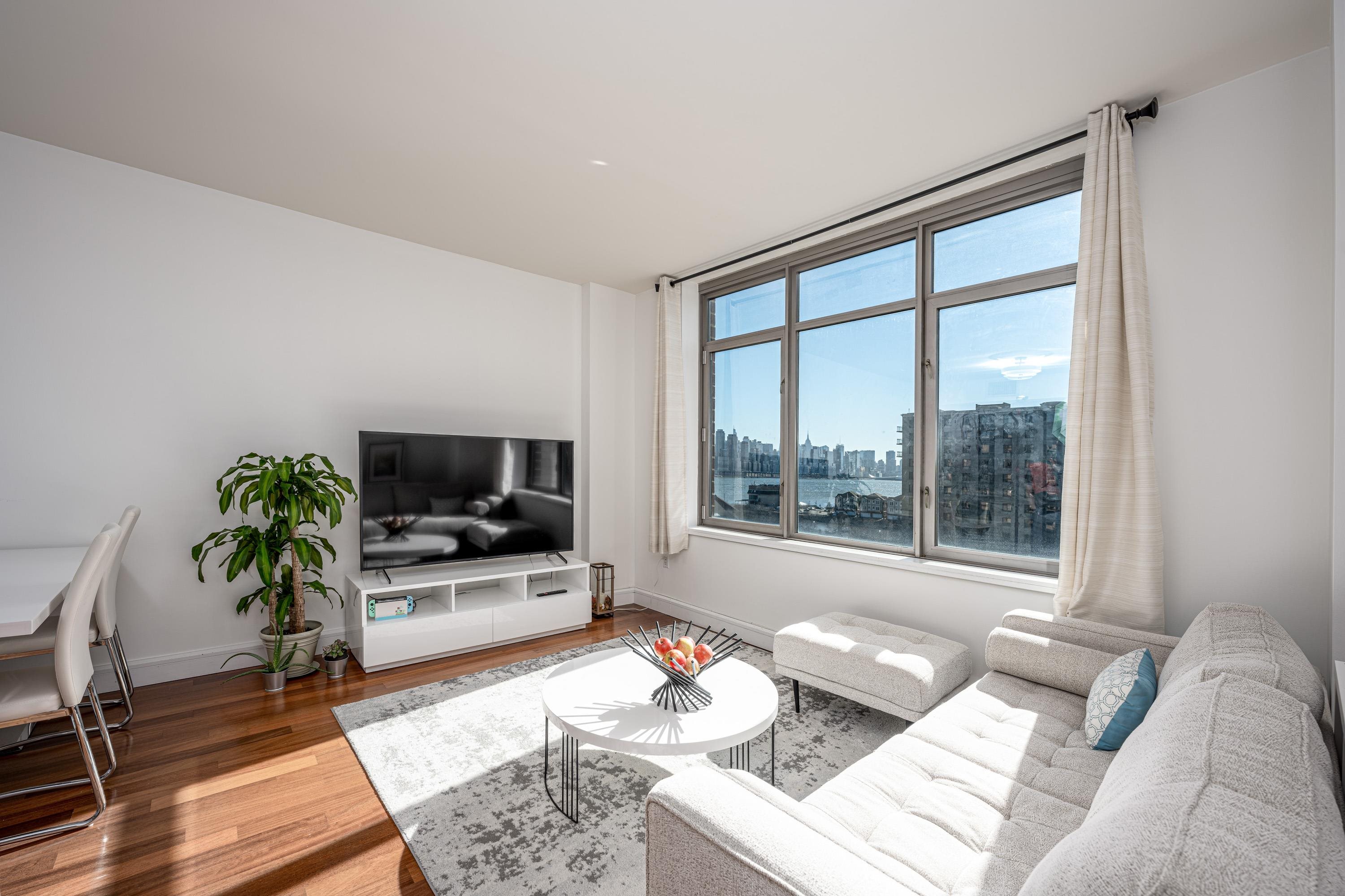8100 River Road, Unit 810 North Bergen, NJ 07047 - Photo 6 of 20 a living room with furniture and a flat screen tv