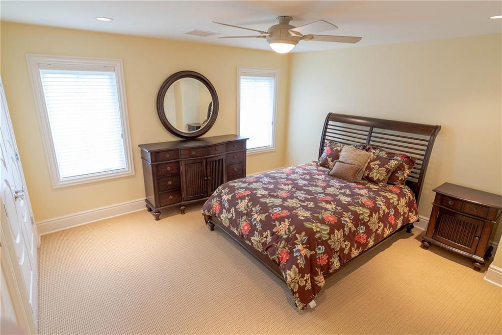 245 Saunders Station Road Trafford, PA 15085 - Photo 17 of 25 a bedroom with a bed a mirror on dresser and a chandelier