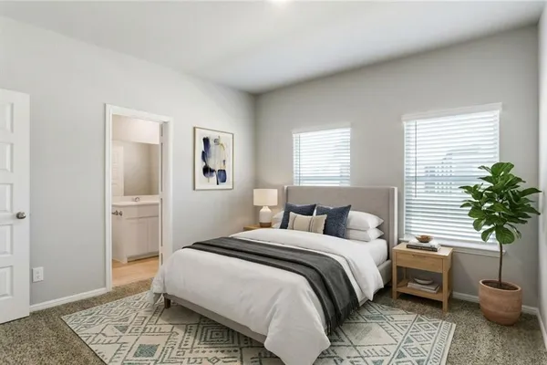 a bedroom with a bed and a potted plant