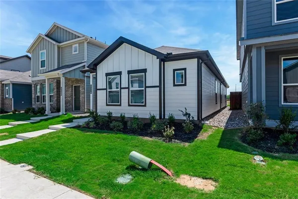 a front view of a house with a garden and plants
