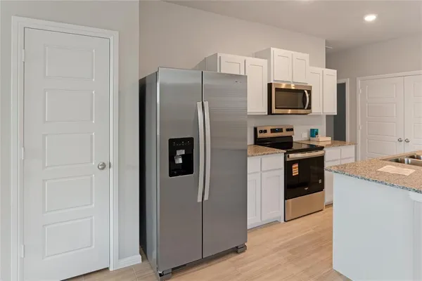 a kitchen with stainless steel appliances a refrigerator stove and microwave