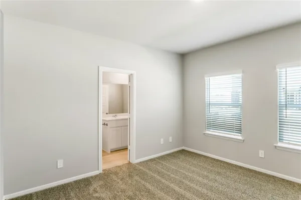 a view of an empty room with window and closet area