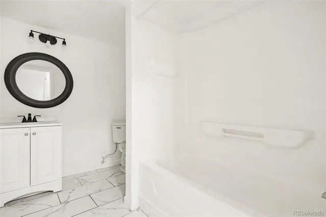 a bathroom with a sink a toilet and a mirror