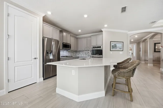 a kitchen with stainless steel appliances kitchen island granite countertop a refrigerator and a stove top oven