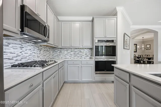 a kitchen with granite countertop a sink a stove and cabinets