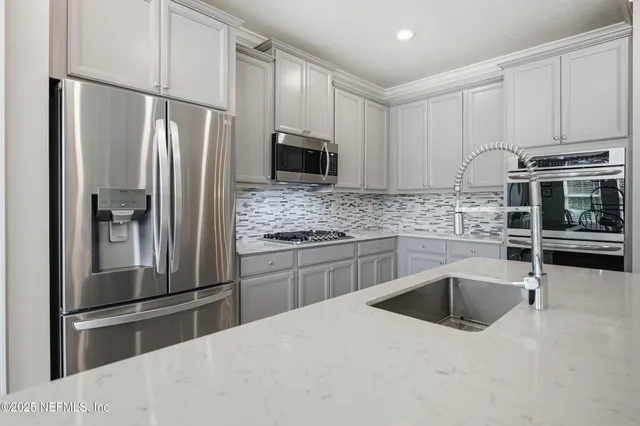 a kitchen with stainless steel appliances a refrigerator sink and microwave