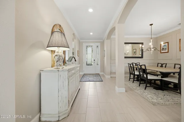 a view of dining room and livingroom with furniture wooden floor a chandelier