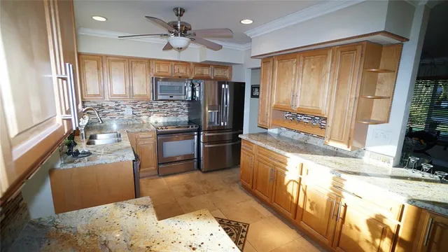 a kitchen with stainless steel appliances granite countertop a refrigerator a stove and a sink with wooden floor