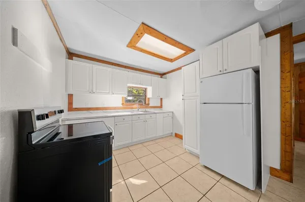 a kitchen with a refrigerator sink and cabinets