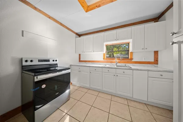 a kitchen with granite countertop white cabinets and white appliances