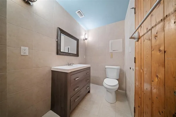 a bathroom with a toilet sink and mirror
