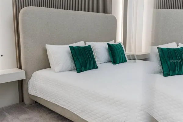 a large bed sitting in a bedroom next to a window