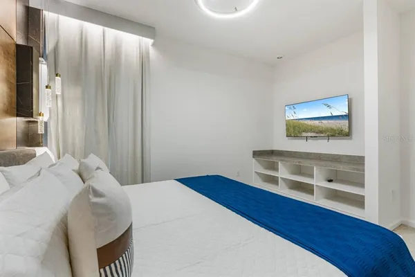a bedroom with a bed and a flat screen tv