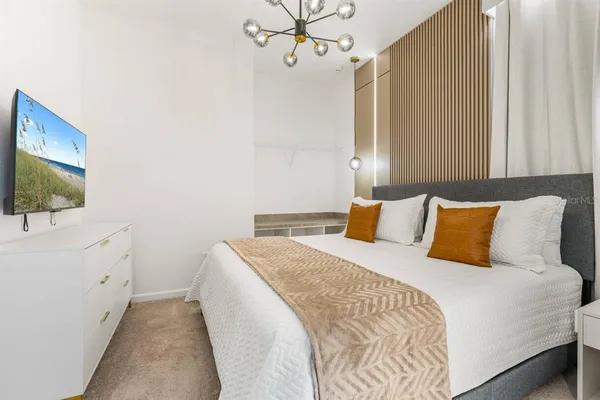 a bed room with a bed tv and a window