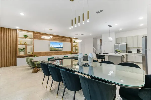 a kitchen with stainless steel appliances granite countertop a sink a stove a dining table and chairs