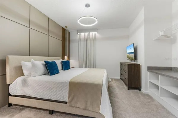 a bedroom with a large bed and a chandelier