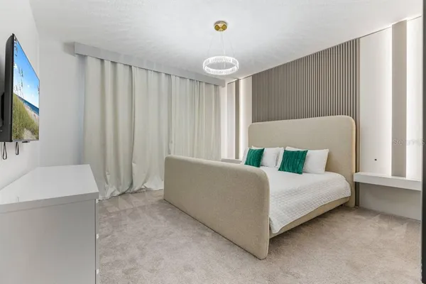 a living room with a bed furniture and a flat tv screen