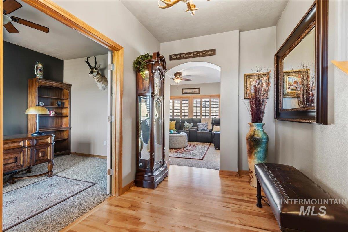 11660 Timber Butte Road Sweet, ID 83670 - Photo 5 of 49 Wood-finish flooring leading to a carpeted room with an arched doorway