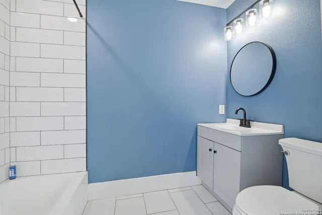 a bathroom with a toilet a sink and mirror