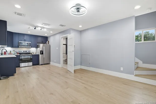 a view of kitchen with stainless steel appliances granite countertop a refrigerator and a sink