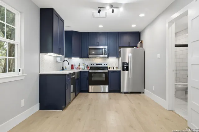 a kitchen with stainless steel appliances granite countertop a refrigerator and a stove top oven