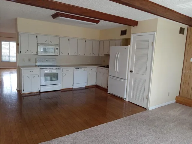 a kitchen with a refrigerator and a stove top oven