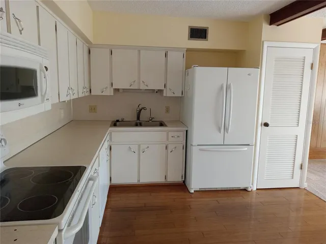 a kitchen with a sink a refrigerator and cabinets