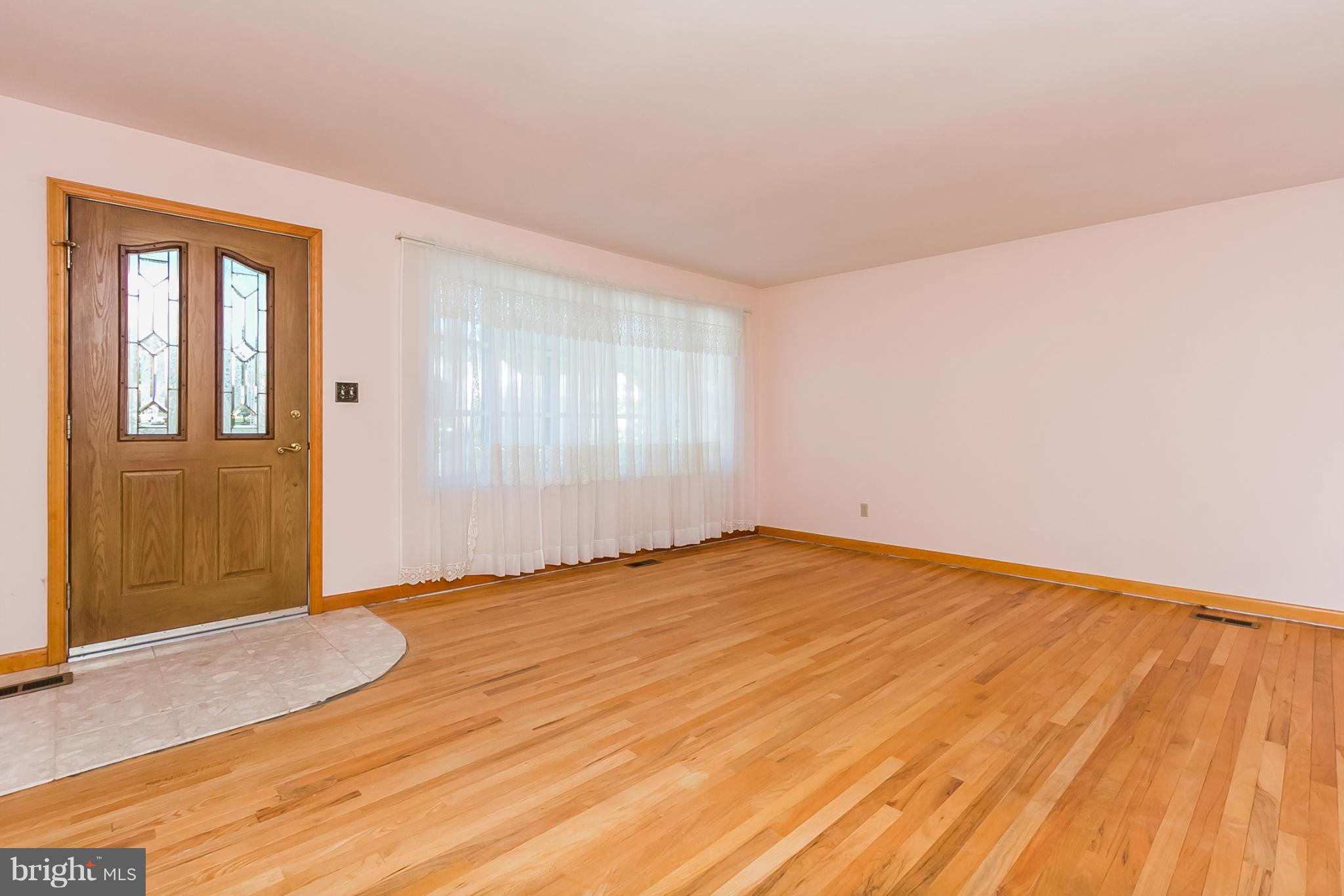 4241 4 Mills Road Baltimore, MD 21236 - Photo 4 of 25 an empty room with wooden floor and windows