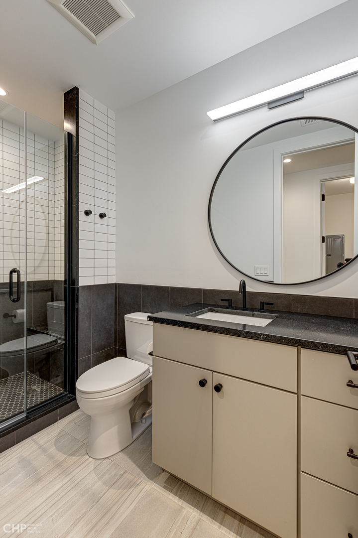 Undisclosed Address Chicago, IL 60622 - Photo 14 of 17 a bathroom with a toilet a sink and mirror