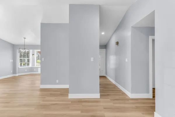 a view of a hallway with wooden floor and staircase