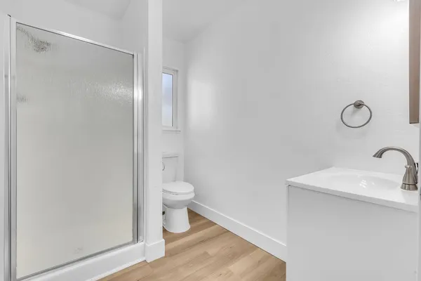 a bathroom with a granite countertop sink toilet and a mirror