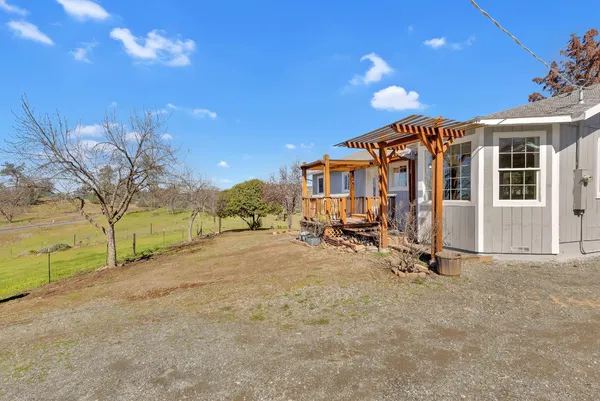 a view of a house with backyard and trees