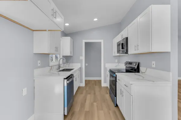 a kitchen with a sink a stove and cabinets
