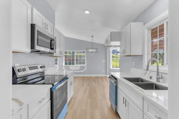 a kitchen that has a sink a stove and cabinets
