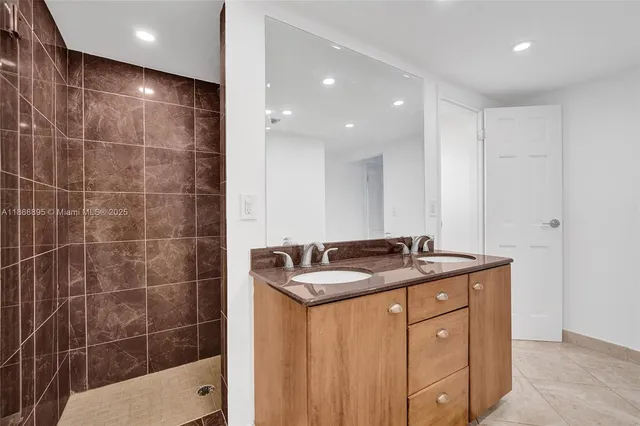 a bathroom with a granite countertop sink a toilet a mirror and shower