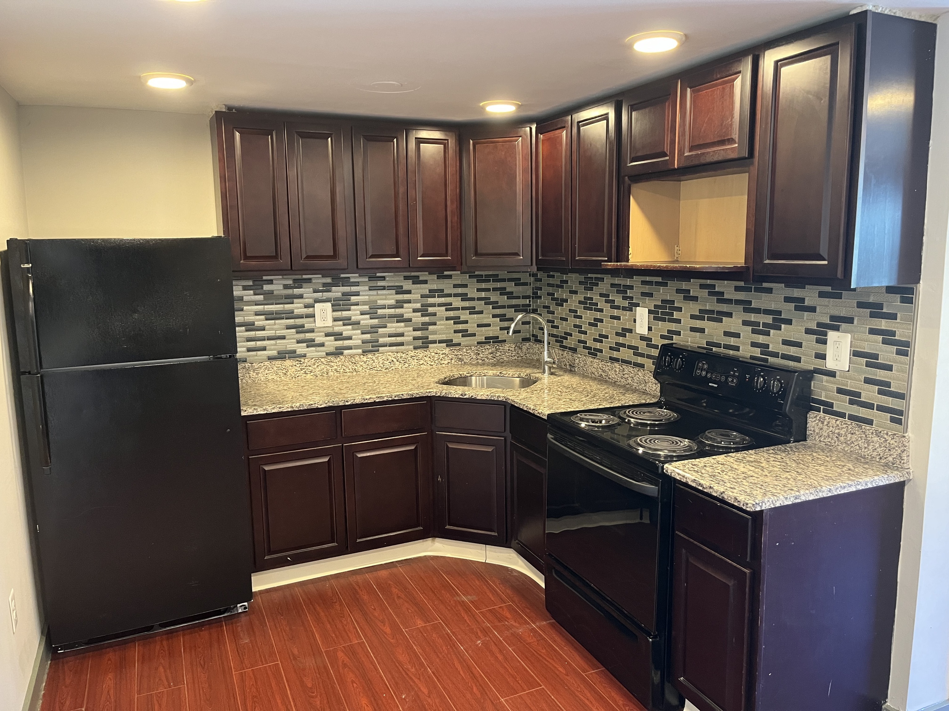32 Cook Avenue, Unit 203 Meriden, CT 06451 - Photo 2 of 11 a kitchen with granite countertop stainless steel appliances and wooden cabinets